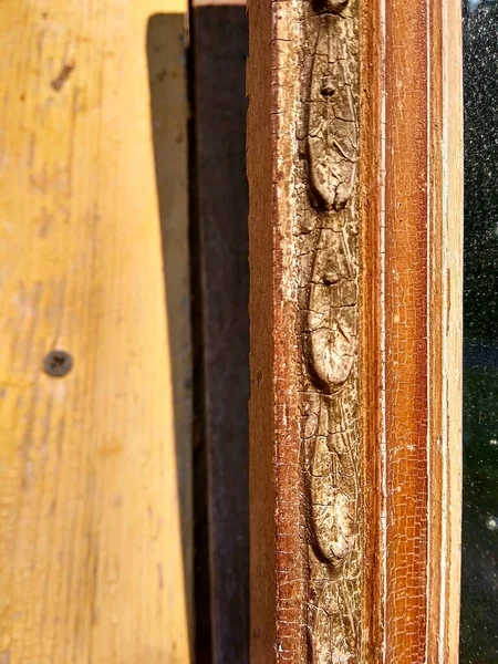 Patterns and patina on an old wooden hanging mirror frame