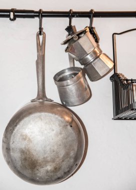 Mutfak gereçleri kahve makinesi, duvarda tava...