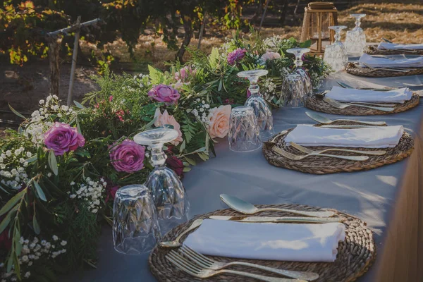 在葡萄园中央摆上金制餐具的宴会桌旁 图库照片