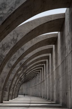 Kemerlerin şeklindeki beton yapı ve bir insanın silüeti