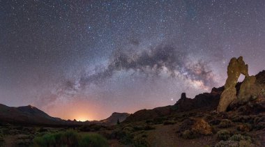 Yıldızlar ve samanyolu ile geceleyin bir dağ manzarası