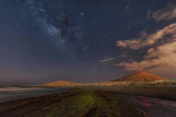 mountain where you can see the milky way the sea and the clouds warm and cold colors
