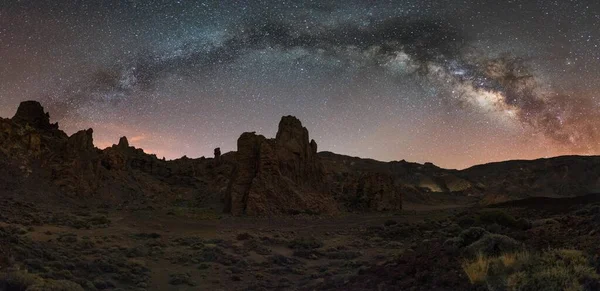 在夜晚与星星和银河相映成趣的山景 图库图片