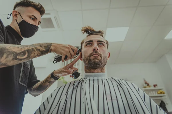 Jovem Com Braços Tatuados Corta Cabelo Homem Uma Barbearia — Fotografia de Stock