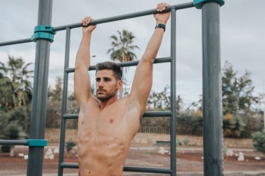 Genç adam dışarıda yüz maskesi takarak egzersiz yapıyor.