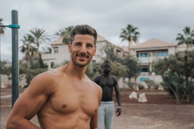 İki genç çok ırklı adam dışarıda egzersiz yapıyor.