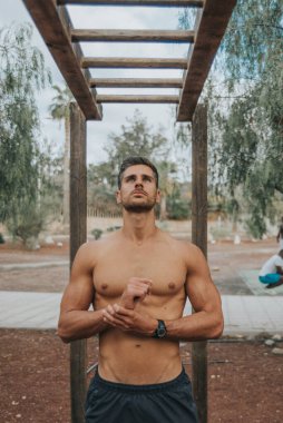 Genç adam dışarıda yüz maskesi takarak egzersiz yapıyor.