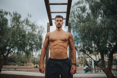 Genç adam dışarıda yüz maskesi takarak egzersiz yapıyor.