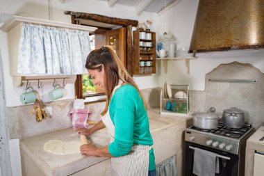 Geleneksel klasik bir mutfakta ev yapımı ekmek yapmak için hamur yapan bir kadın.