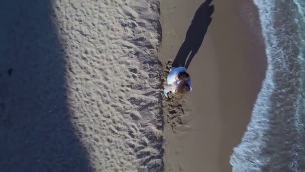 L'homme et la femme se tiennent sur la mer avec plusieurs personnes qui nagent à la journée ensoleillée d'été. Vue aérienne 