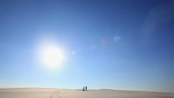 Pareja romántica caminando cogidos de la mano bajo el sol. Dos jóvenes amantes caminando alegres juntos en el romance en verano.Maspalomas dunas de arena, Gran Canaria, Islas Canarias, España — Vídeos de Stock