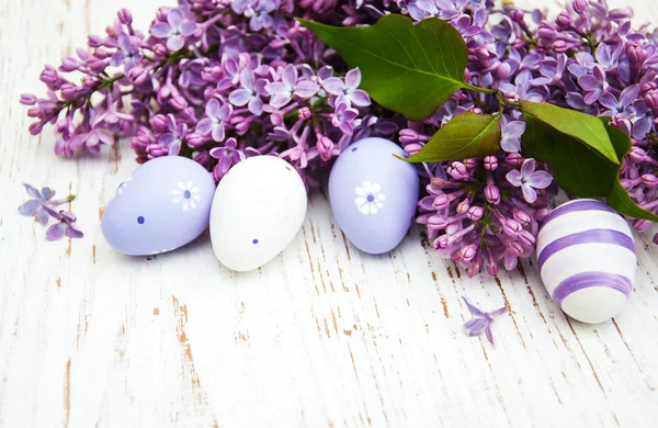 Huevos de pascua y flores frescas de lila — Foto de Stock