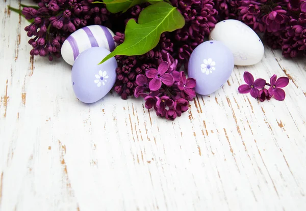 Huevos de pascua y flores frescas de lila — Foto de Stock