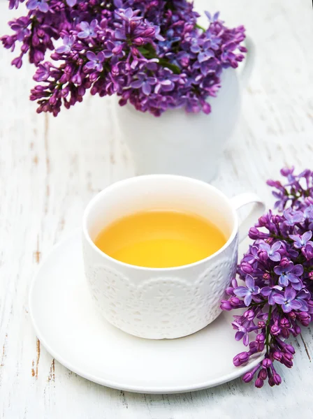 Cup of tea and lilac flowers — Stock Photo, Image