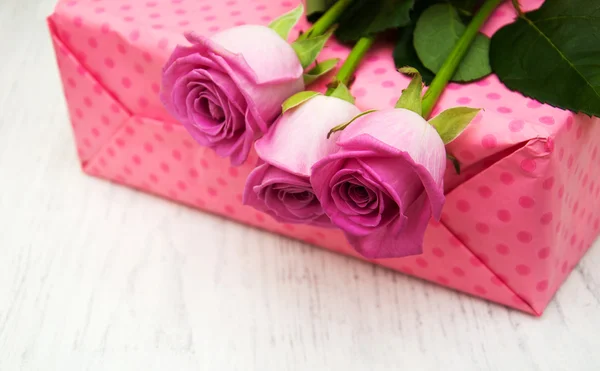 Розовые розы и подарочная коробка — стоковое фото