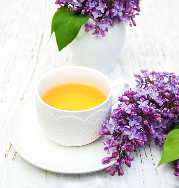 Cup of tea and lilac flowers — Stock Photo, Image