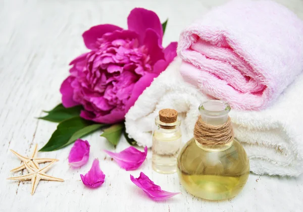Peony bloemen, massage olie en handdoeken — Stockfoto