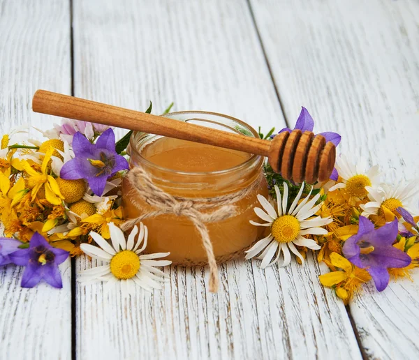 Jar of honey with wildflowers — Stock Photo, Image