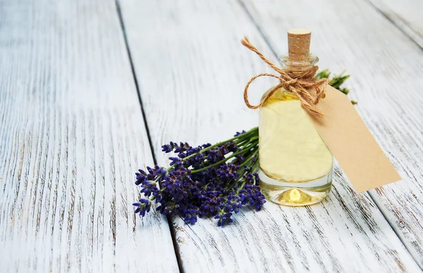 Petrol, boş etiket ve lavanta çiçekleri ile şişe