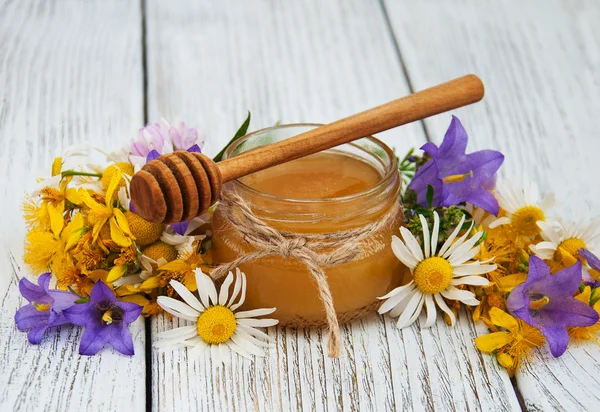 Jar of honey with wildflowers — Stock Photo, Image