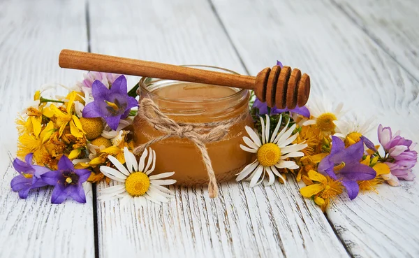 Jar of honey with wildflowers — Stock Photo, Image