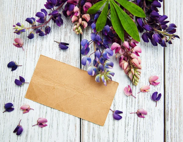 Lupine flowers with vintage card on a  table — Stock Photo, Image