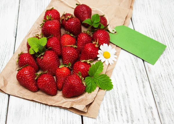 ripe strawberries with paper tag on wooden table