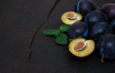 Fresh plums with green leaves
