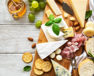 Beyaz ahşap arka planda çeşitli peynir çeşitleri