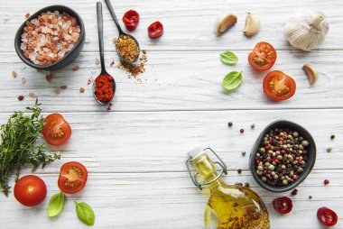 Beyaz ahşap arka planda sarımsaklı domates, fesleğen ve biber.