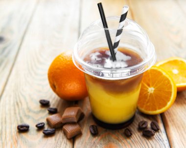 Eski ahşap arka planda portakal ve kahve kokteyli.