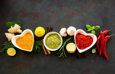 Siyah beton arka planda bir kasede çeşitli baharatlar. Üst görünüm kopyalama alanı.