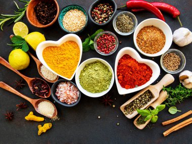 Siyah beton arka planda bir kasede çeşitli baharatlar. Üst görünüm kopyalama alanı.