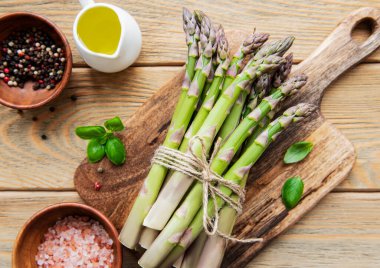 Bir sürü çiğ kuşkonmaz, ahşap zemin üzerinde farklı baharat ve malzemeler barındırır. Üst manzara, düz uzanma.