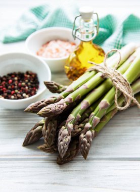 Bir sürü çiğ kuşkonmaz, ahşap zemin üzerinde farklı baharat ve malzemeler barındırır. Üst manzara, düz uzanma.