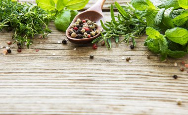 Ahşap arka planda taze otlar ve baharatlar.