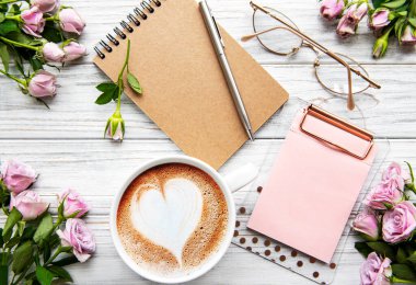 Çalışma alanı, günlük, defter, pano, beyaz arka planda güller. Merkez ofis masası. Üst görünüm kadınsı arka plan. Düz yatış, üst görünüm