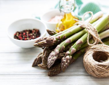 Bir sürü çiğ kuşkonmaz, ahşap zemin üzerinde farklı baharat ve malzemeler barındırır. Üst manzara, düz uzanma.