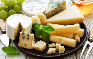 Beyaz ahşap arka planda çeşitli peynir çeşitleri