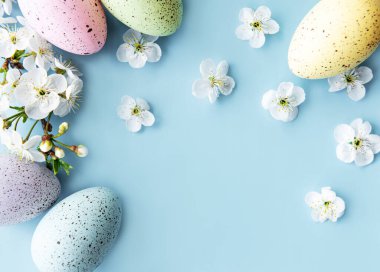 Bahar çiçekleri açan renkli Paskalya yumurtaları mavi arka plan. Renkli Yumurta Tatil Kenarı. 