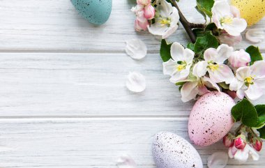 Ahşap arka planda bahar çiçekleri olan renkli Paskalya yumurtaları. Renkli Yumurta Tatil Kenarı. 