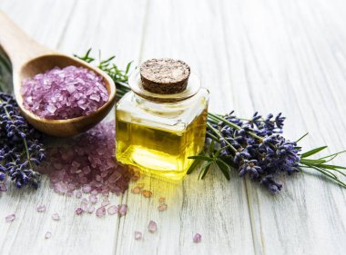 Lavantalı doğal organik SPA kozmetik seti. Tahta zemine banyo tuzu ve masaj yağı serpiştirilmiş. Cilt bakımı, güzellik tedavi konsepti