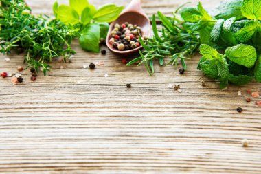 Ahşap arka planda taze otlar ve baharatlar.
