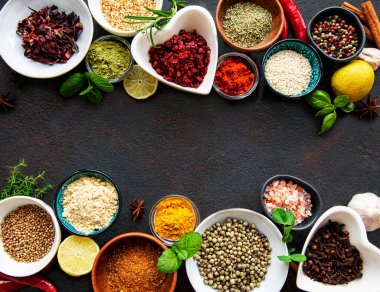 Siyah beton arka planda bir kasede çeşitli baharatlar. Üst görünüm kopyalama alanı.