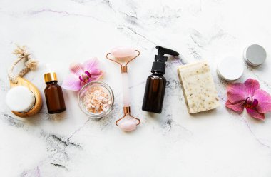 Mermer arka planda sıfır atık banyo aksesuarı ve yeşim taşlı silindir. Düz yatıyordu