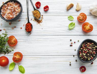 Beyaz ahşap arka planda sarımsaklı domates, fesleğen ve biber.