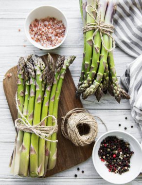 Bir sürü çiğ kuşkonmaz, ahşap zemin üzerinde farklı baharat ve malzemeler barındırır. Üst manzara, düz uzanma.