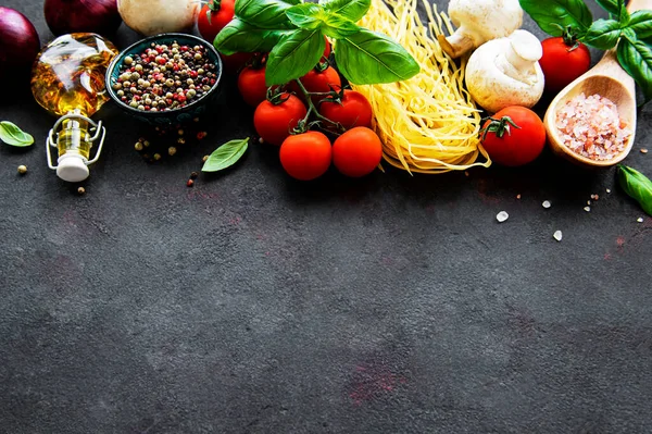stock image Healthy mediterranean diet, ingredients for Italian meal, spaghetti, tomatoes, basil, olive oil, garlic, peppers on black background