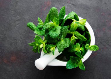 Taş masada taze nane yaprakları var. Üst görünüm
