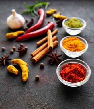 Siyah beton arka planda bir kasede çeşitli baharatlar. Üst görünüm kopyalama alanı.